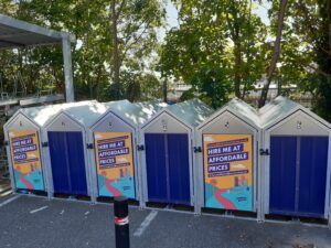 Picture showing secure cyle parking huts with blue doors and apex roofs